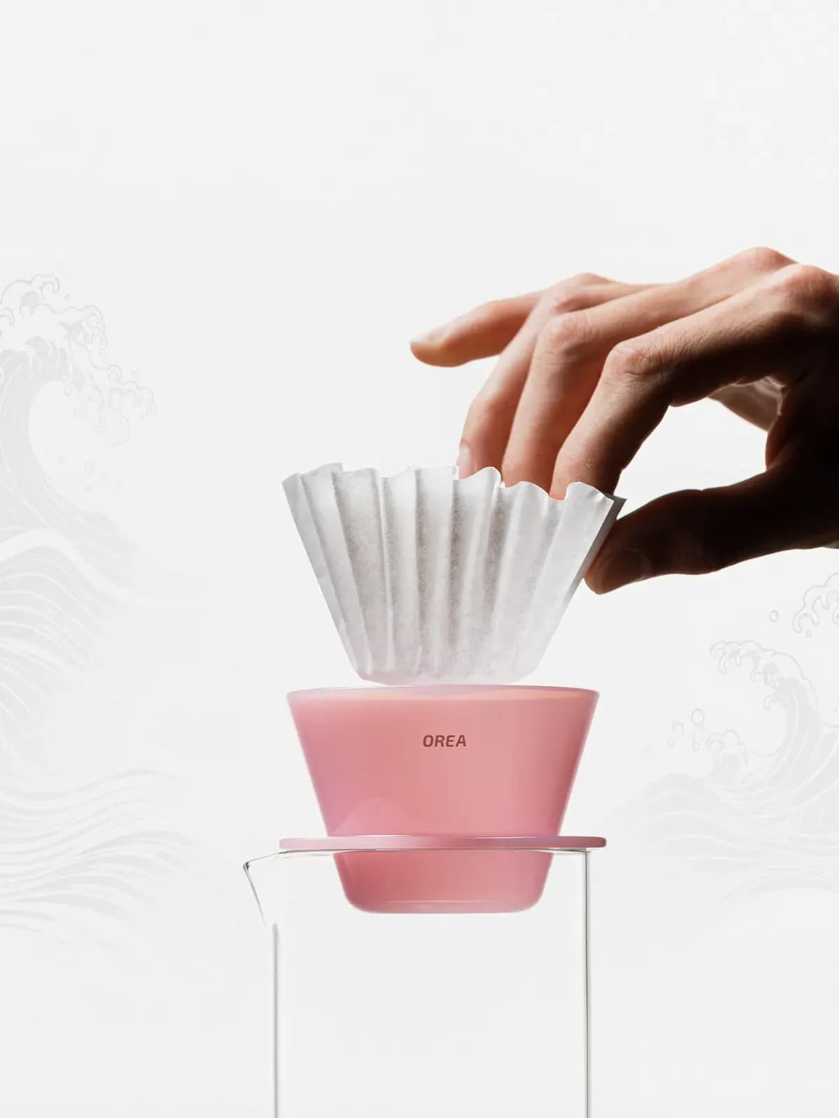 Orea O1 Creamy Pink auf einer Glaskanne, ein Papierfilter wird eingesetzt