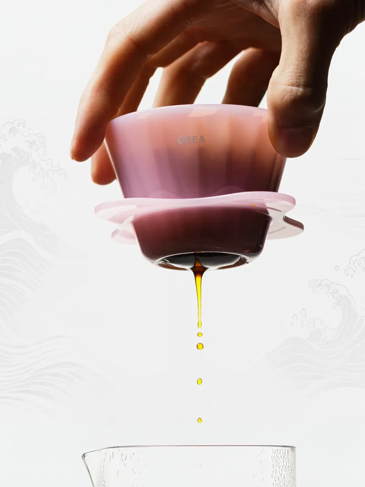 Orea O1 Creamy Pink in der Hand, Kaffee tropft in eine Glaskanne