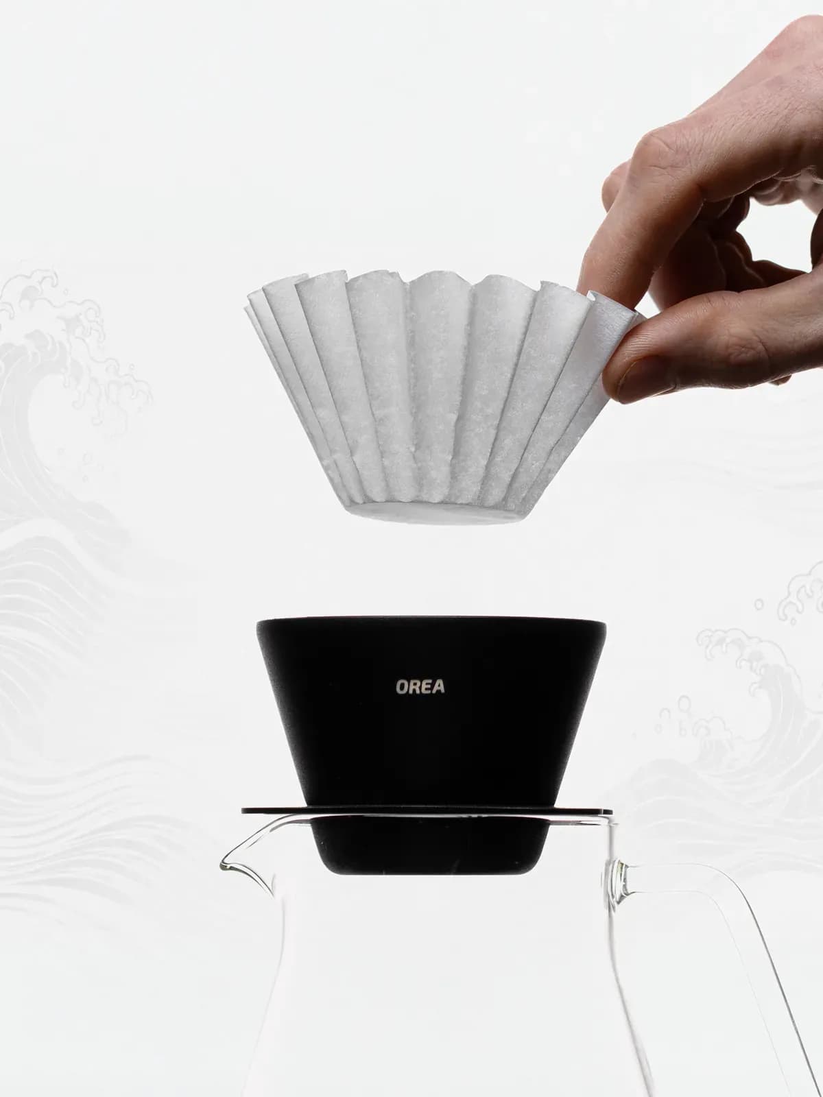 Orea O1 Steel Obsidian auf einer Glaskanne, ein Papierfilter wird eingesetzt