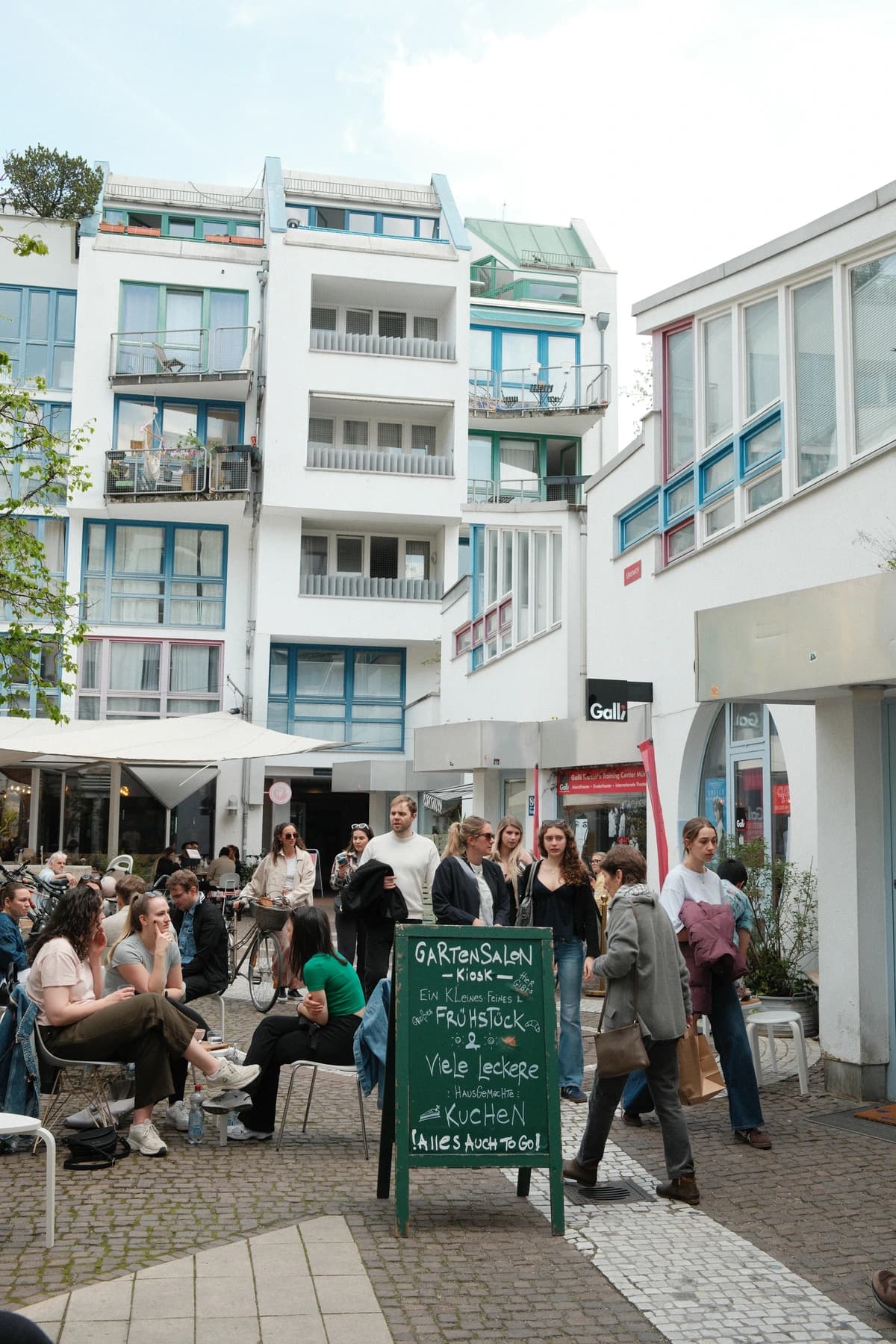 Der Hof der Amalienpassage in Münchens Maxvorstadt, belebt mit Gästen an den Café-Tischen, wo Humpback Whale versteckt liegt